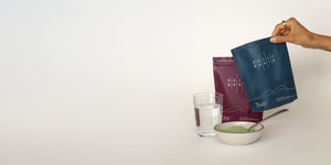 DailyBasis pouches with glass of water and bowl of supplement powder.